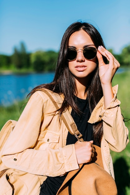 young female traveler holding sunglasses