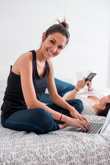 Young female using laptop in bedroom