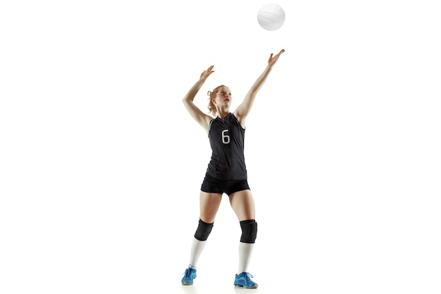 Free photo young female volleyball player isolated on white wall. woman in sport's equipment and shoes or sneakers training and practicing. concept of sport, healthy lifestyle, motion and movement.