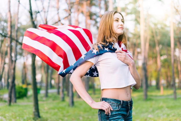 Young female wearing American flag as cape