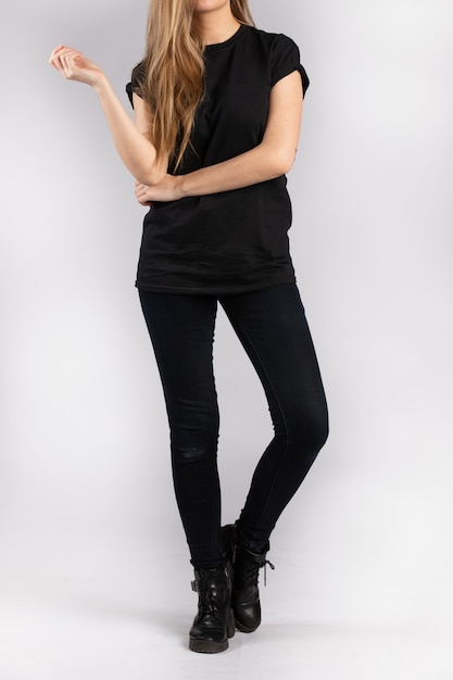 Free photo young female wearing black short sleeve t-shirt standing against a white wall