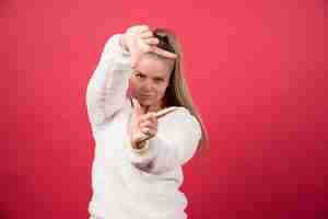 Free photo a young female wearing sweater showing something small in size with hands