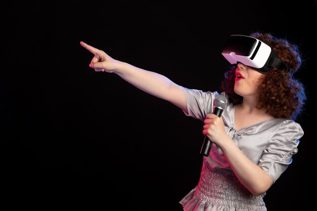 マイクゲーム音楽d技術ビデオとバーチャルリアリティヘッドセットを身に着けている若い女性