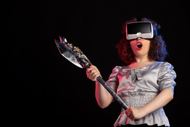 Young female wearing vr headset with battle axe on dark floor d warrior vikings samurai