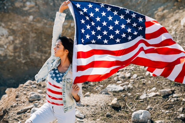 よそ見アメリカの国旗を持つ若い女性