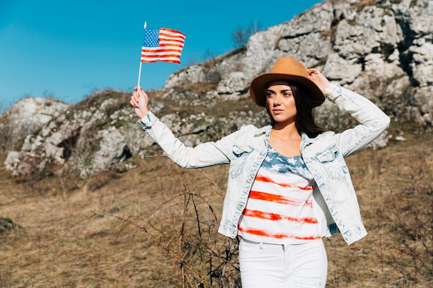 Young female with American flag in nature 