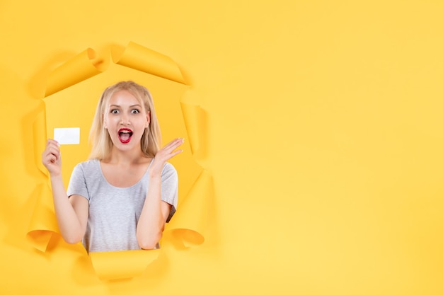 Young female with credit card on yellow background money sale shopping facial