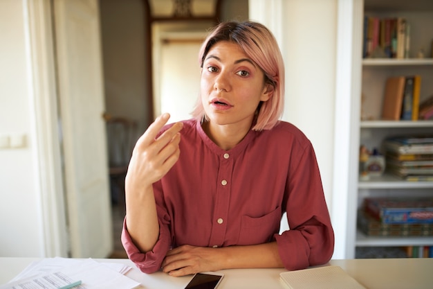 ピンクがかった髪のポーズの若い女性