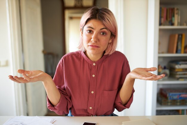 ピンクがかった髪のポーズの若い女性