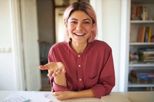 ピンクがかった髪のポーズの若い女性