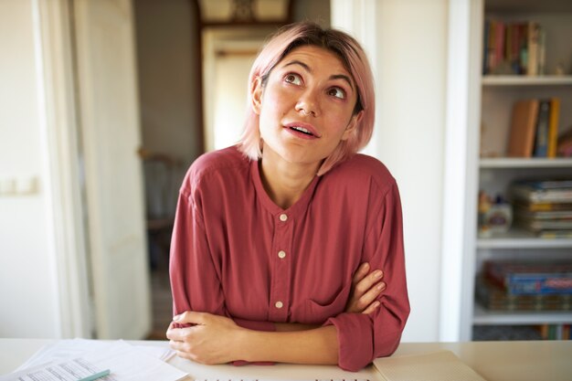 ピンクがかった髪のポーズの若い女性