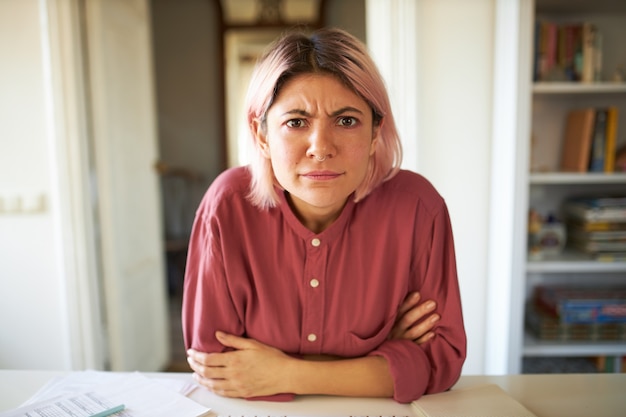 ピンクがかった髪のポーズの若い女性