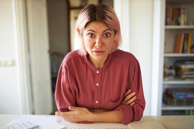 ピンクがかった髪のポーズの若い女性