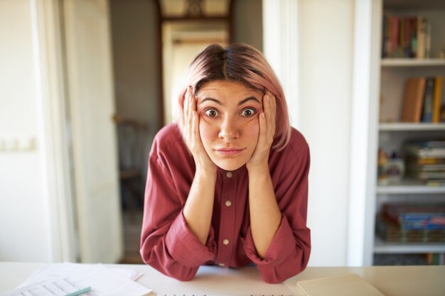 ピンクがかった髪のポーズの若い女性