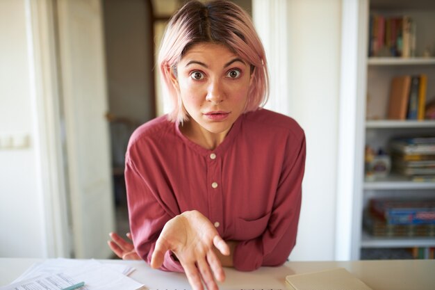 ピンクがかった髪のポーズの若い女性