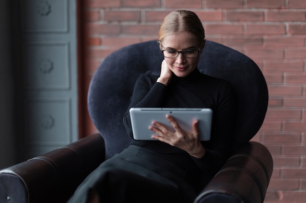 ソファの上のタブレットで若い女性