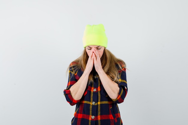 Free photo young female woman in a checkered shirt with a hat