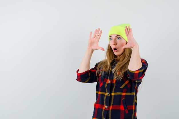 Free photo young female woman in a checkered shirt with a hat