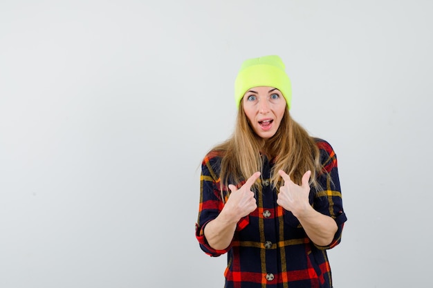 Free photo young female woman in a checkered shirt with a hat