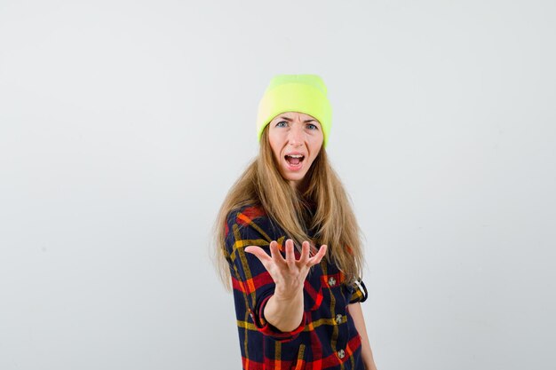 Young female woman in a checkered shirt with a hat