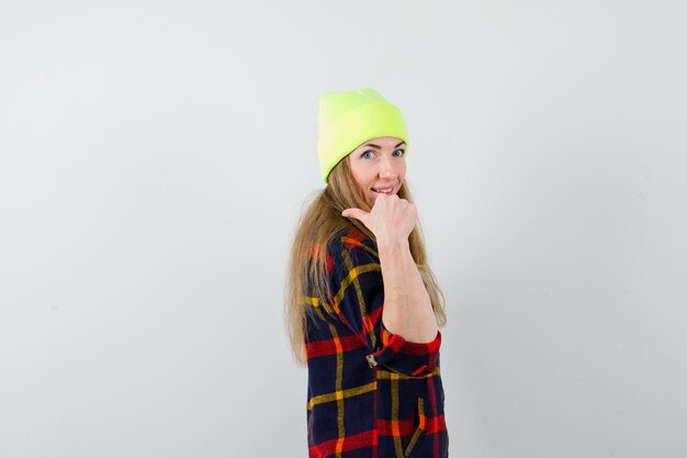 Молодая женщина в клетчатой рубашке с шляпой