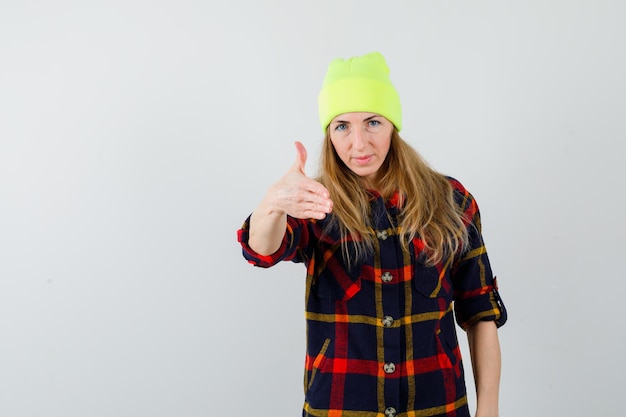 Young female woman in a checkered shirt with a hat