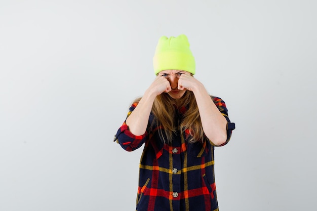 Young female woman in a checkered shirt with a hat