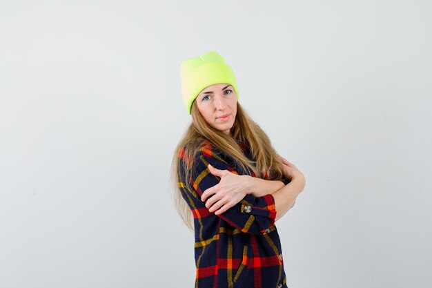 Молодая женщина в клетчатой рубашке с шляпой