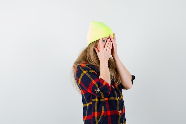 Бесплатное фото Молодая женщина в клетчатой рубашке с шляпой