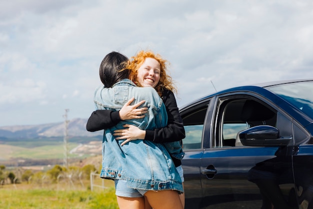Young females hugging on roadside