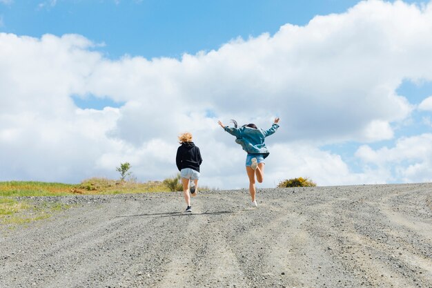 Young females jumping on empty road