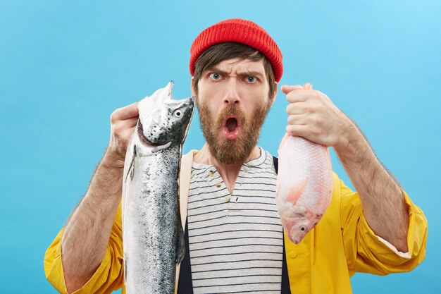 young fisherman showing two fishes to the camera