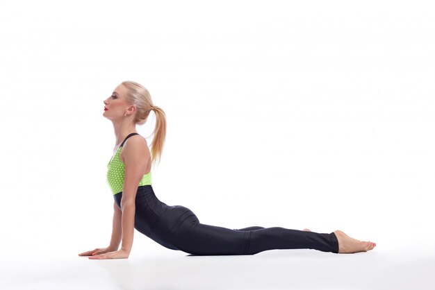 young fit female practicing yoga stretching her back