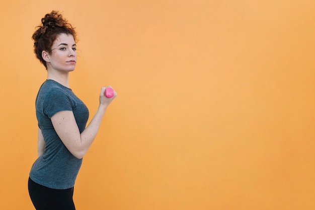 Free photo young fit woman with dumbbell