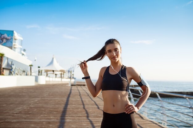 молодая фитнес-девушка готова к занятиям спортом у моря