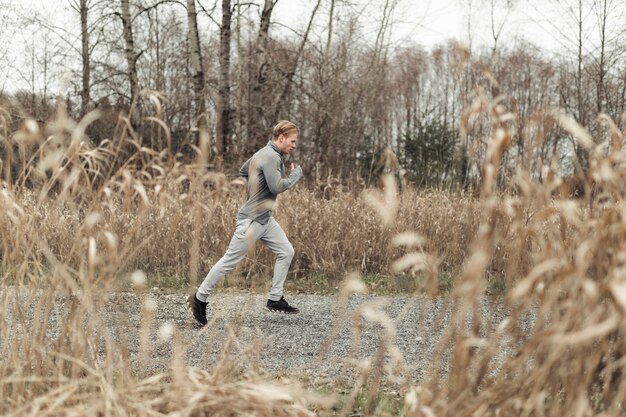 Young fitness male athlete running in the farm