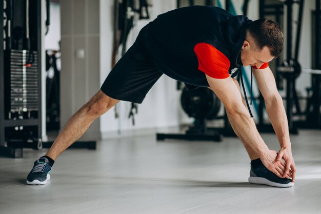 Young fitness trainer stretching at the gym