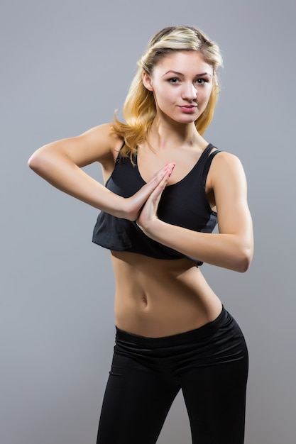 Young fitness woman in sport style standing against white background. isolated