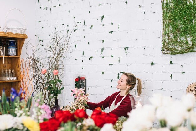 Foto gratuita giovane fiorista ammirando il bouquet