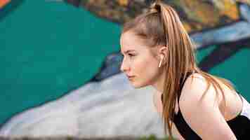 Free photo young focused blonde woman at outdoors training resting after running, multicolored background