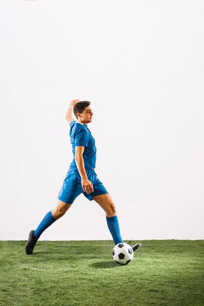 Young football player crossing ball