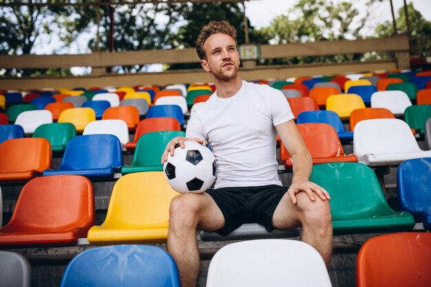 Young football player at tribunes watching the game