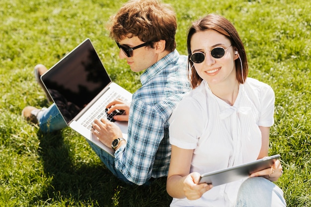 Free photo young freelancer couple working outdoors