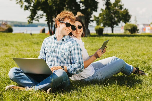 Foto gratuita giovani freelancers che sorridono nel parco