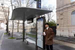 무료 사진 버스 역에서 기다리고 커피를 마시는 젊은 프랑스 남자