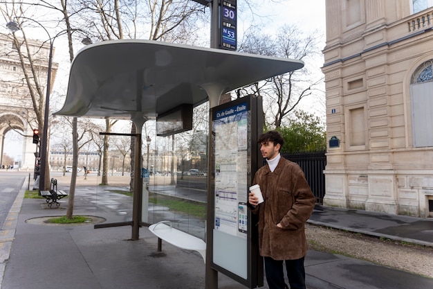 バスを待って、コーヒーを飲みながら駅で待っている若いフランス人