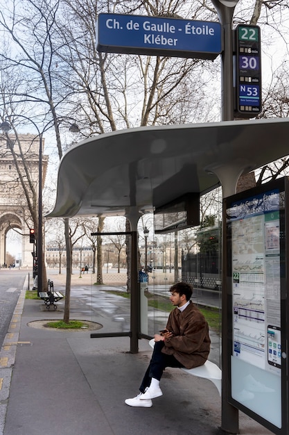 Молодой француз ждет на вокзале автобус