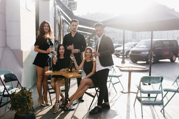 Young friends drinking champagne on a terrace