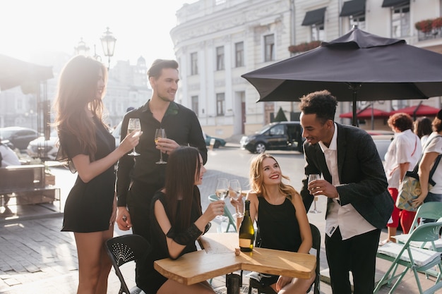 Giovani amici che bevono champagne su una terrazza