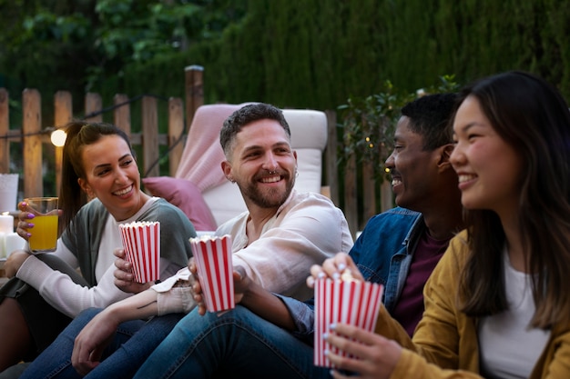 Foto gratuita giovani amici che si divertono al cinema all'aria aperta